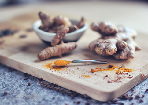 Fresh raw ginger root on a wooden table, a natural remedy for reducing chemotherapy-induced nausea